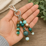 Beaded handbag charm held in a hand with a wooden background