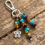 Butterfly purse charm with silver clasp on a wooden surface