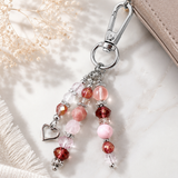 Beaded purse charm with pink and heart beads on a neutral background