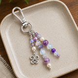 Purple purse charm with a butterfly charm on a ceramic plate