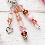 Beaded purse charm with a heart charm on a light wooden surface