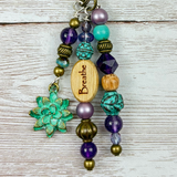Beaded yoga purse charm with 'Breathe' wooden charm on a wooden surface