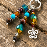 Colorful beaded keychain with a decorative butterfly charm on a wooden surface