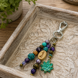 Beaded lotus flower purse charm with a wooden tag on a decorative wooden tray